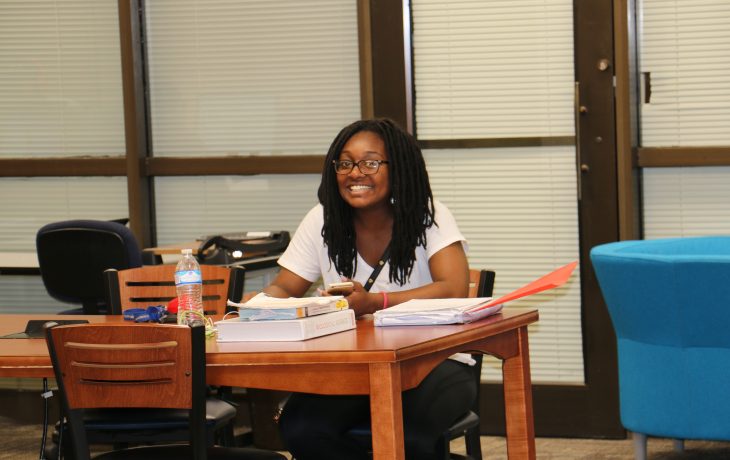 Student at library smiling at camera