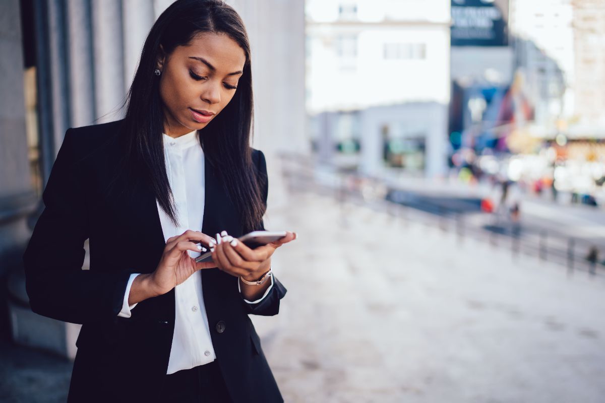 Young woman looking down at cell phone in her hand