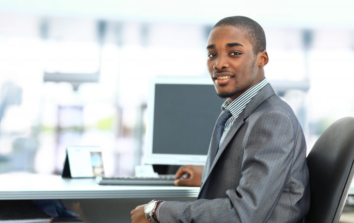 Student seated at table smiling at camera