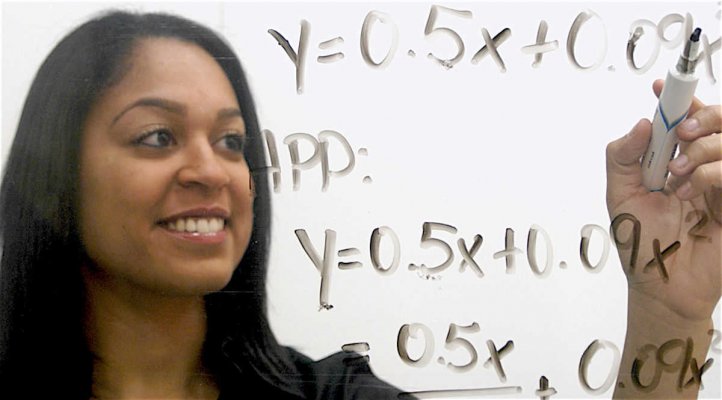 Teacher writing algebra on a white board