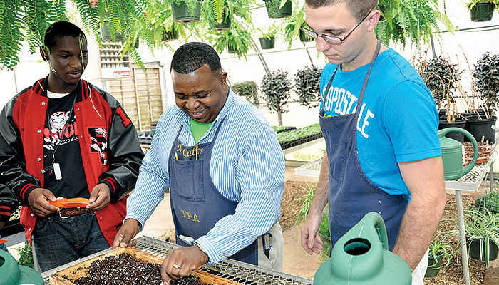 Instructor planting seeds with students