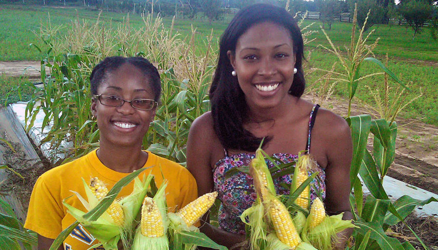 Two students holding up corn