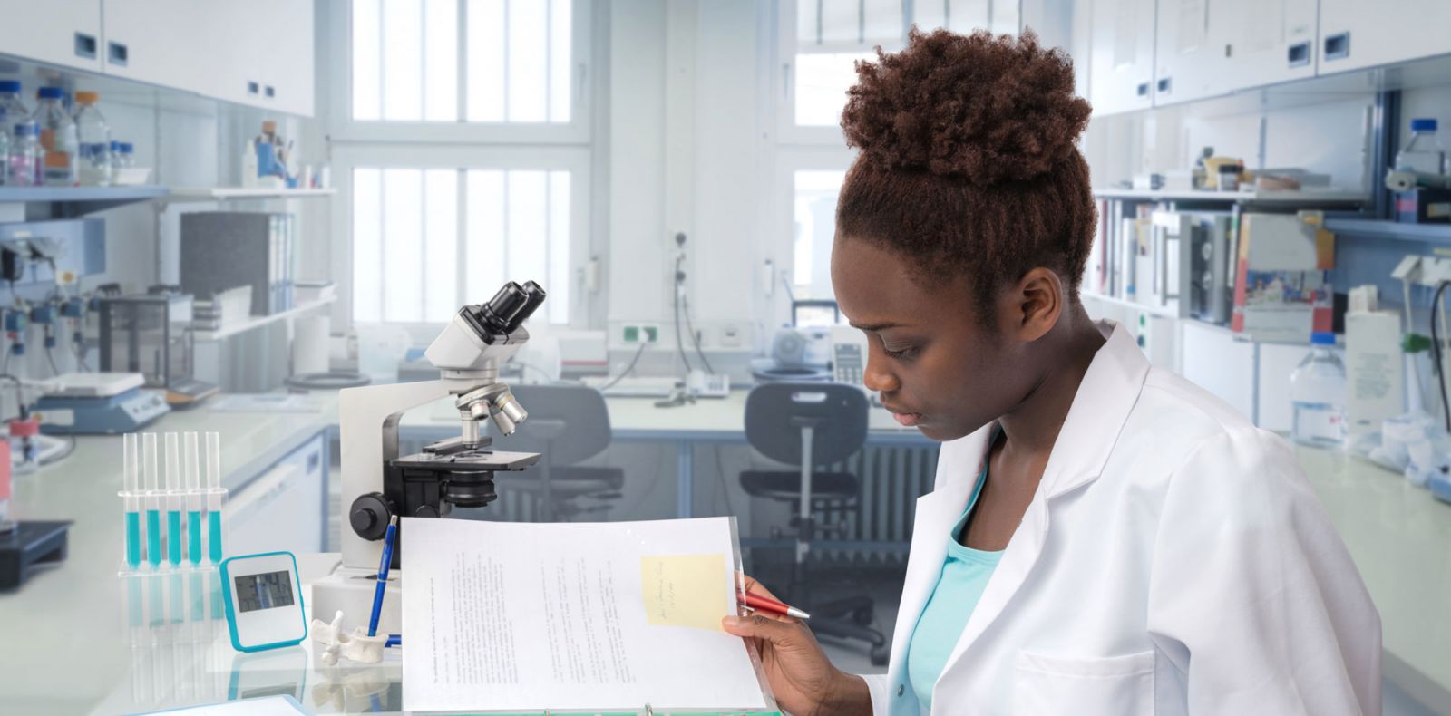 Young woman in lab reading notes