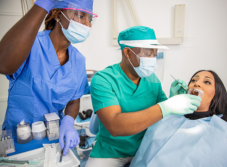Two dentistry technicians working with a patient
