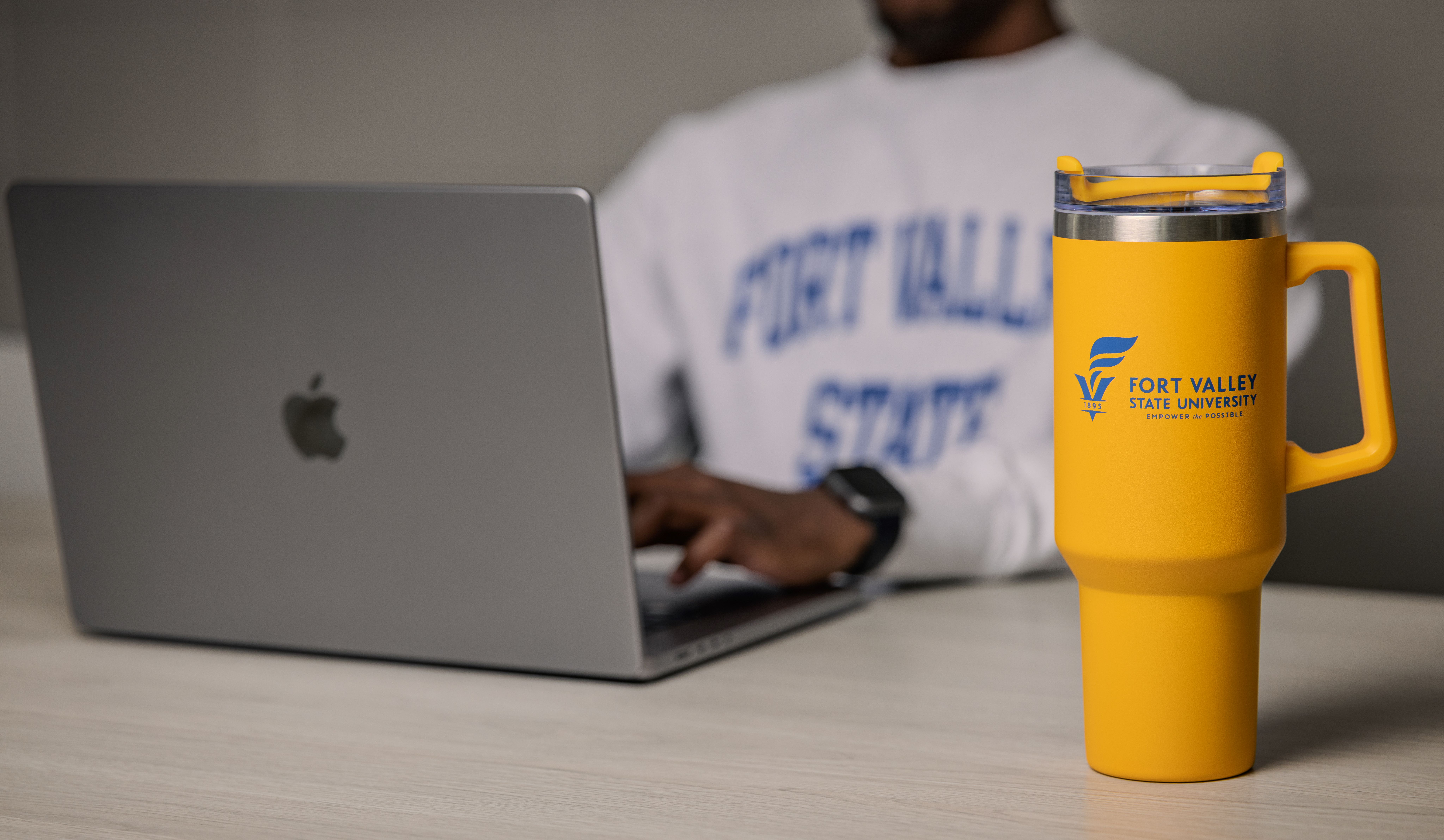 student typing on a Macbook