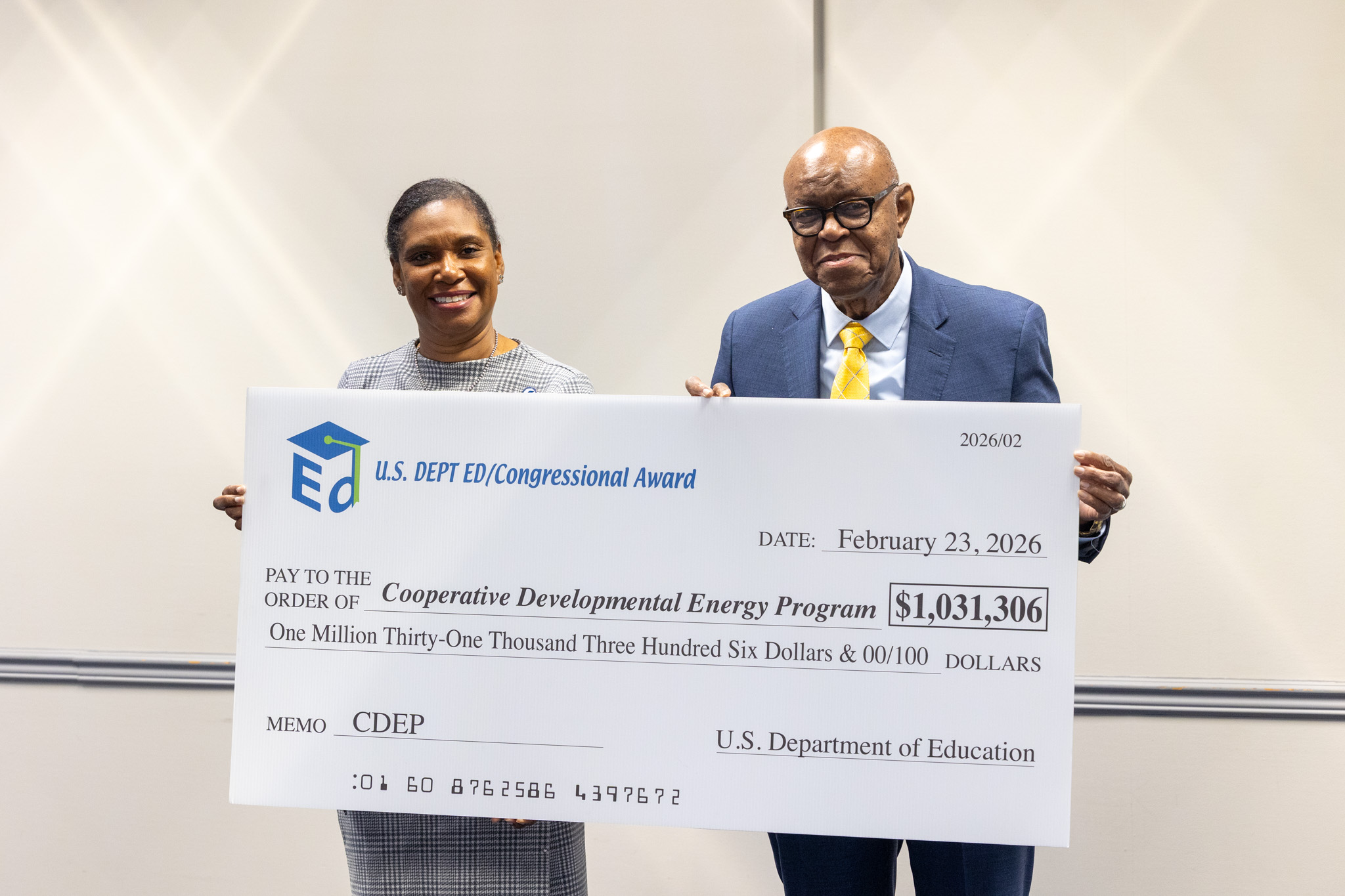 two people in photo holding a large check