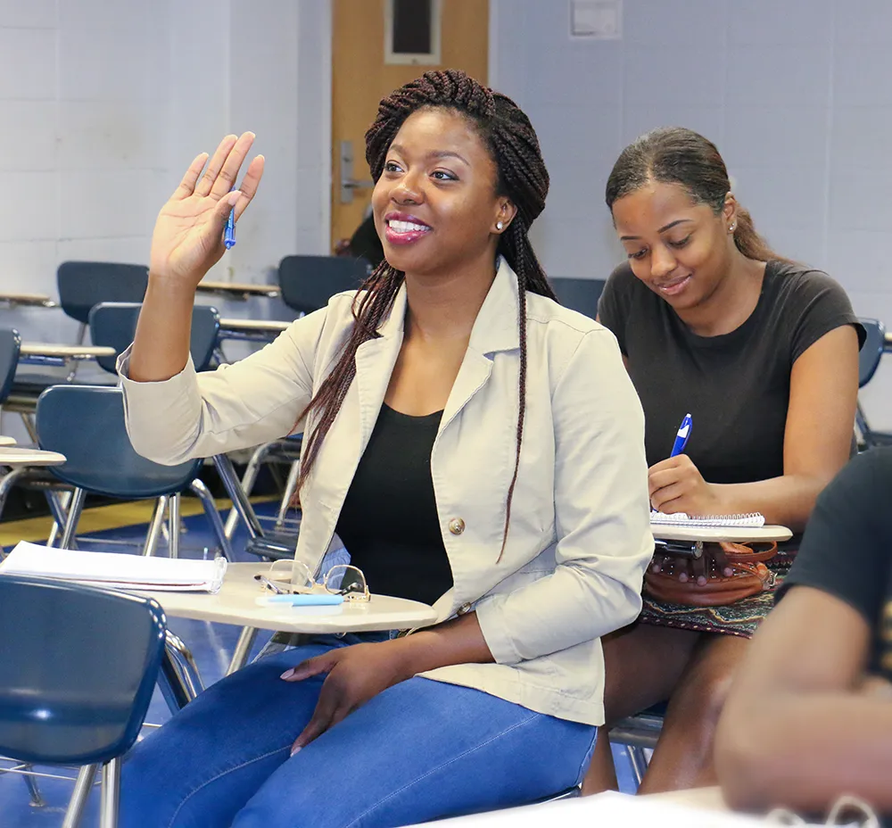 Female student raising hand to answer question