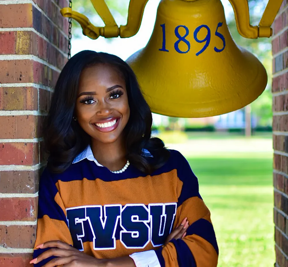 FVSU student posing next to the bell